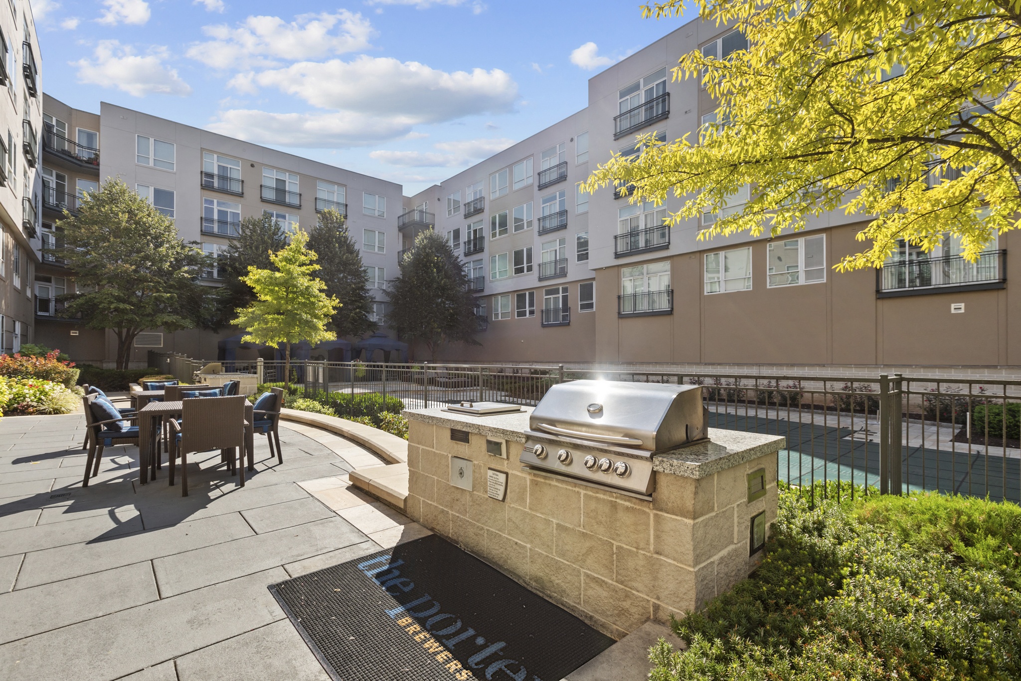 an outdoor patio with a grill and a table with chairs